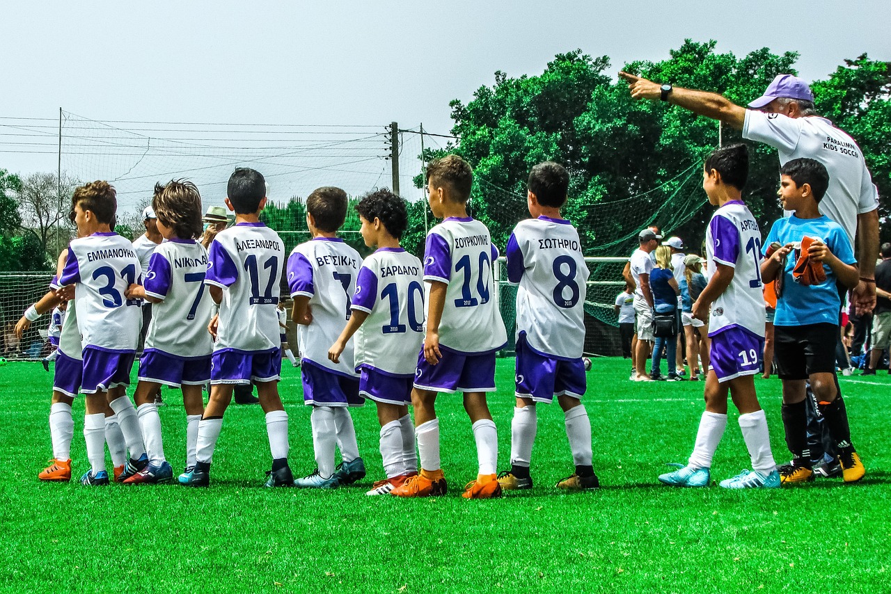 Coach instructing young players on the soccer field